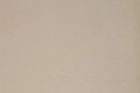 Beige background in small polka dots from smooth thick cardboard, close-up,.. Stock Photos