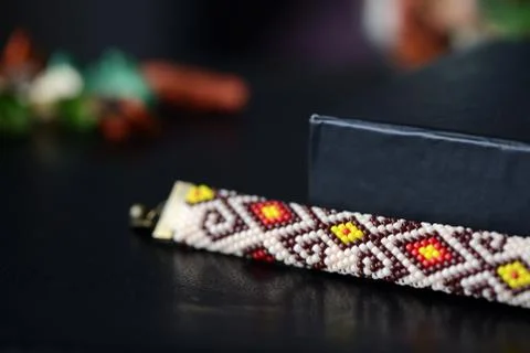 Beige beaded bracelet with oriental pattern on a dark background close up Stock Photos