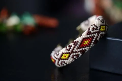 Beige beaded bracelet with oriental pattern on a dark background close up Stock Photos