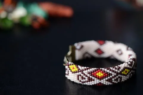 Beige beaded bracelet with oriental pattern on a dark background close up Stock Photos