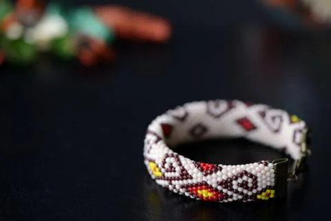 Beige beaded bracelet with oriental pattern on a dark background close up Stock Photos