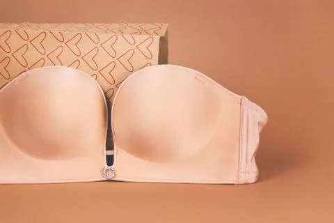 Beige bra on the background of the gift pack in bright colours Stock Photos