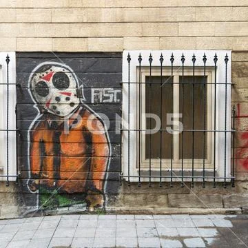 Beige bricks external wall with graffiti drawing and closed window Stock Photos