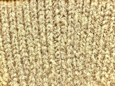 Beige cable knit wool texture macro plush soft fuzzy cozy ribbed yarn fabri.. Stock Photos