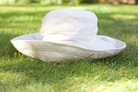 Beige canvas sun hat lying on lawn Stock Photos