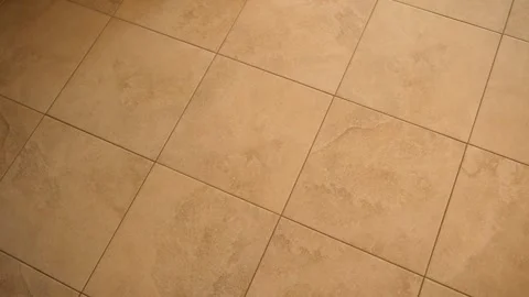 Beige ceramic floor tiles in warm light, square tile pattern with grout lines, Stock Footage 347010990