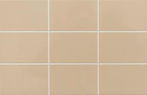 Beige ceramic tile on the wall in the bathroom. Background from beige tiles. Stock Photos