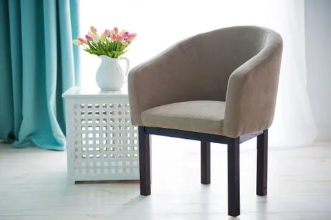 Beige chair on the background of the window. The interior of the apartment Stock Photos
