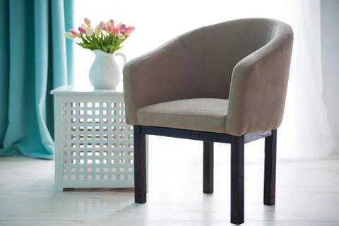 Beige chair on the background of the window. The interior of the apartment Stock Photos