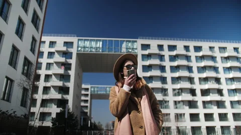 Beige clothes and a hat on a young girl in dark glasses. Blue sky and white Stock Footage 191830590