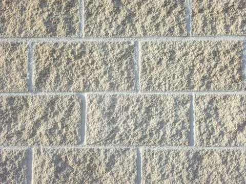 Beige concrete block wall with rough texture arranged in running bond pattern 스톡 사진