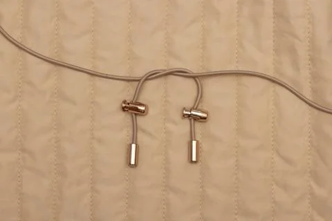 Beige drawstring with metal gold jacket retainer. Stock Photos