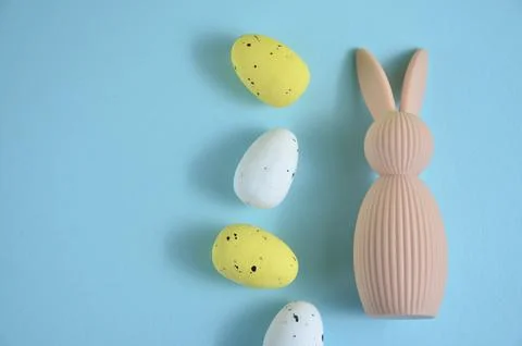 Beige Easter bunny and eggs on a blue background. Easter. Stock-Fotos