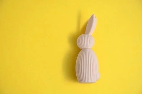 Beige Easter bunny on a yellow background. Easter. 库存照片