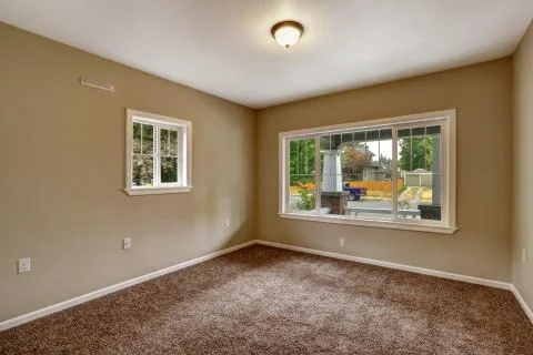 Beige empty room with brown carpet floor Stock Photos
