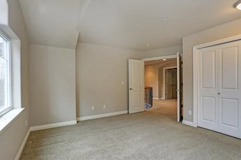 Beige empty room interior with built in closet, carpet floor and large window Stock Photos