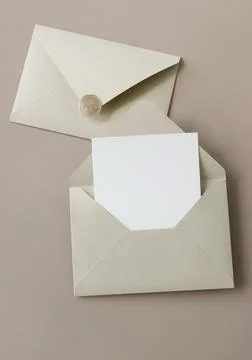 Beige envelope with blank paper card mockup inside top view on beige background  Stock Photos