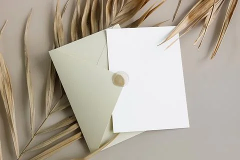 Beige envelope with blank paper card mockup inside top view on beige background  Stock Photos