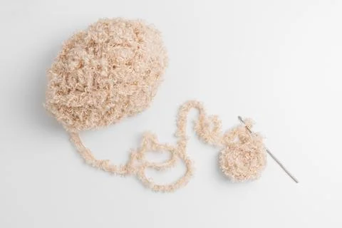 Beige fluffy yarn ball using crochet hook Stock Photos