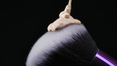 Beige foundation pours on a makeup brush Stock Footage 166493767