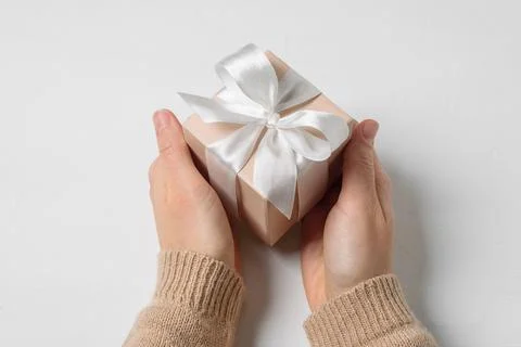Beige gift box in hands Stock Photos