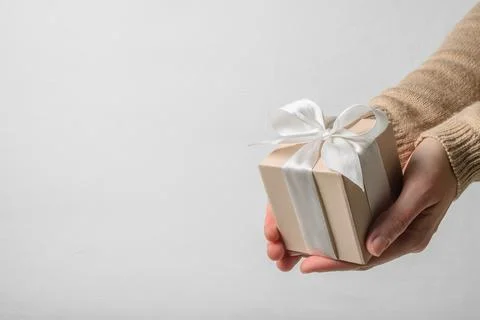 Beige gift box in hands Stock Photos