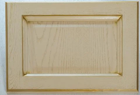 Beige kitchen facade close-up. background of yellow wooden decorative item Stock Photos