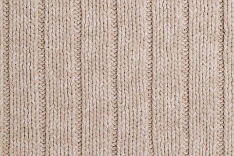 Beige knitted abstract background. Texture of a beige wool sweater. Stock Photos