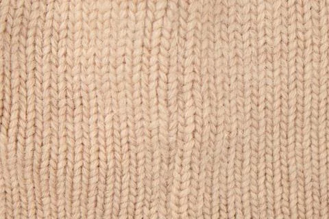 Beige knitted fabric texture. Close up of soft wool yarn textile surface. Pat Stock Photos
