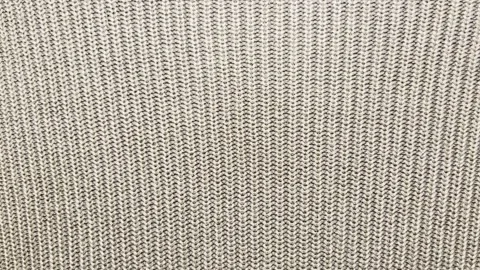 Beige knitted fabric texture glides smoothly in cinematic macro panning shot sho Stock Footage 337550400