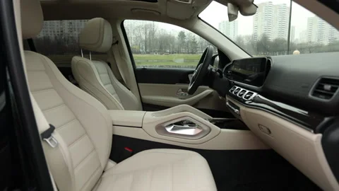 Beige leather interior of a premium SUV with wood trim and a huge multimedia Stock Footage 162982914