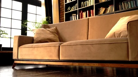 Beige leather sofa in an interior room with a bookcase. Stock Footage 125337752