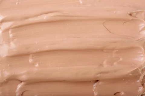 Beige liquid foundation makeup as a background. Top view. Flat lay pattern Stock Photos
