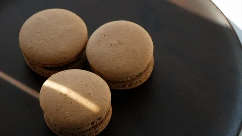 Beige macaroons on a dark plate Stock Footage 108166436