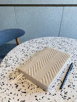 Beige notebook and pen on a table in cafe Foto stock