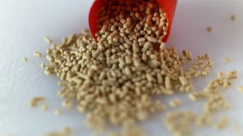 Beige pellets spilled out of the red capsule. Tablet extreme close-up, real time Stock Footage 129298059