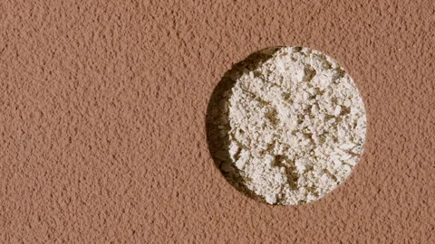 Beige powder texture revealed beneath brown sifted surface Stock Footage 338350051