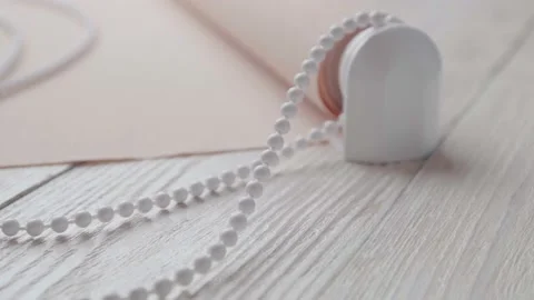 Beige roller blind and spare parts on a white wooden table. Stock-Footage 147961844