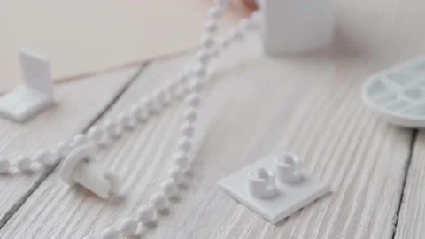 Beige roller blind and spare parts on a white wooden table. Stock-Footage 147961854