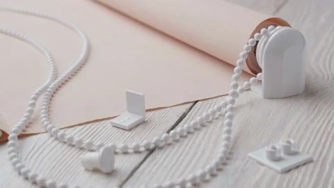 Beige roller blind and spare parts on a white wooden table. Stock-Footage 147961862