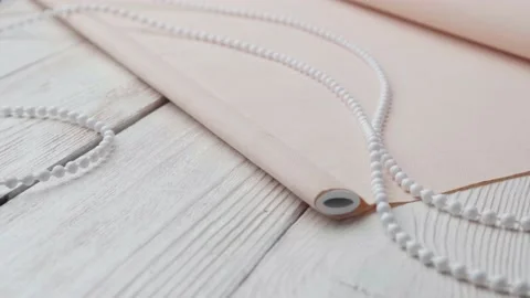 Beige roller blind and spare parts on a white wooden table. Stock-Footage 147961868