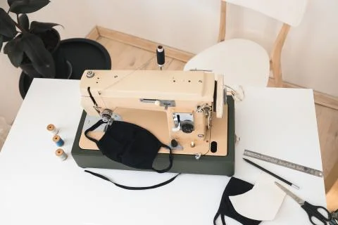 Beige sewing machine the process of sewing a protective medical mask at home Stock Photos
