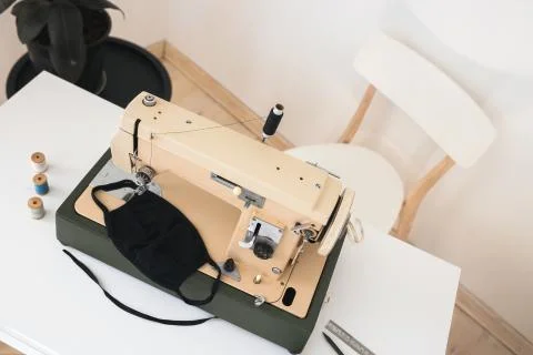 Beige sewing machine the process of sewing a protective medical mask at home Stock Photos