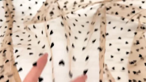 Beige sheer mesh fabric features a tiny black velvet heart pattern Video stock 333777868