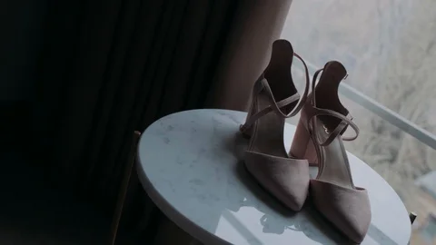 Beige shoes lie on the table Stock Footage 122127124