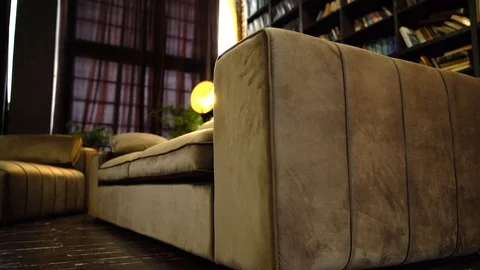 Beige sofa against a red brick wall and books Stock Footage 125337269