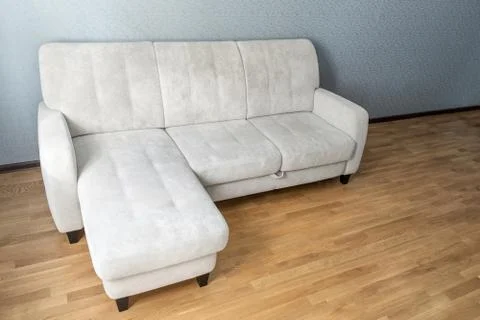 Beige Sofa on laminate floor in empty living room Stock Photos