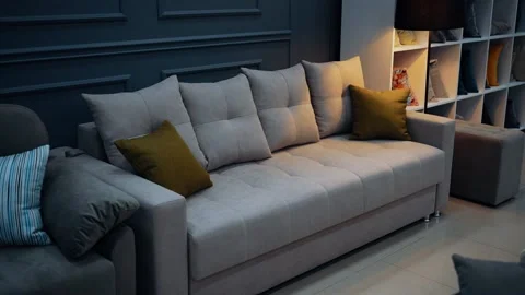 Beige sofa, stylish with four large beige pillows, two small yellow pillows Stock Footage 235058843