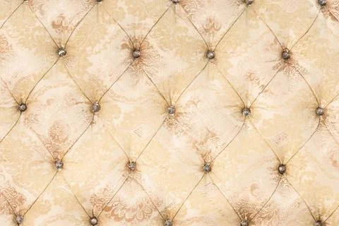 Beige soft tapestry pattern background with symmetrical buttons on the cor... Stock Photos