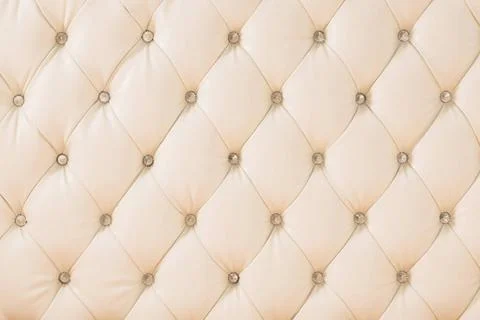 Beige soft tapestry pattern background with symmetrical buttons on the cor... Stock Photos